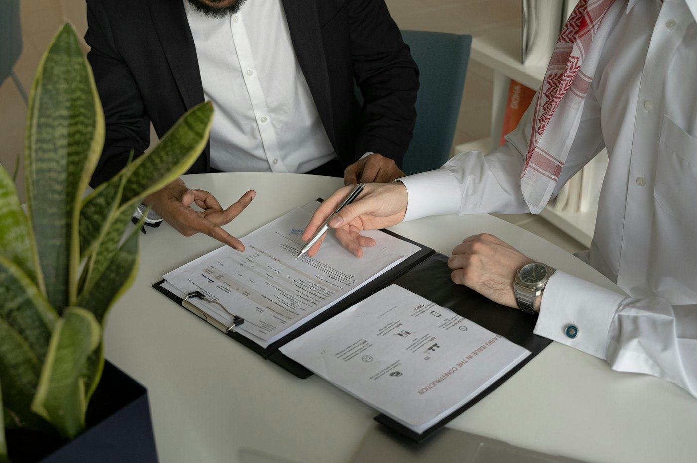 Two people reviewing and signing loan documents at a desk