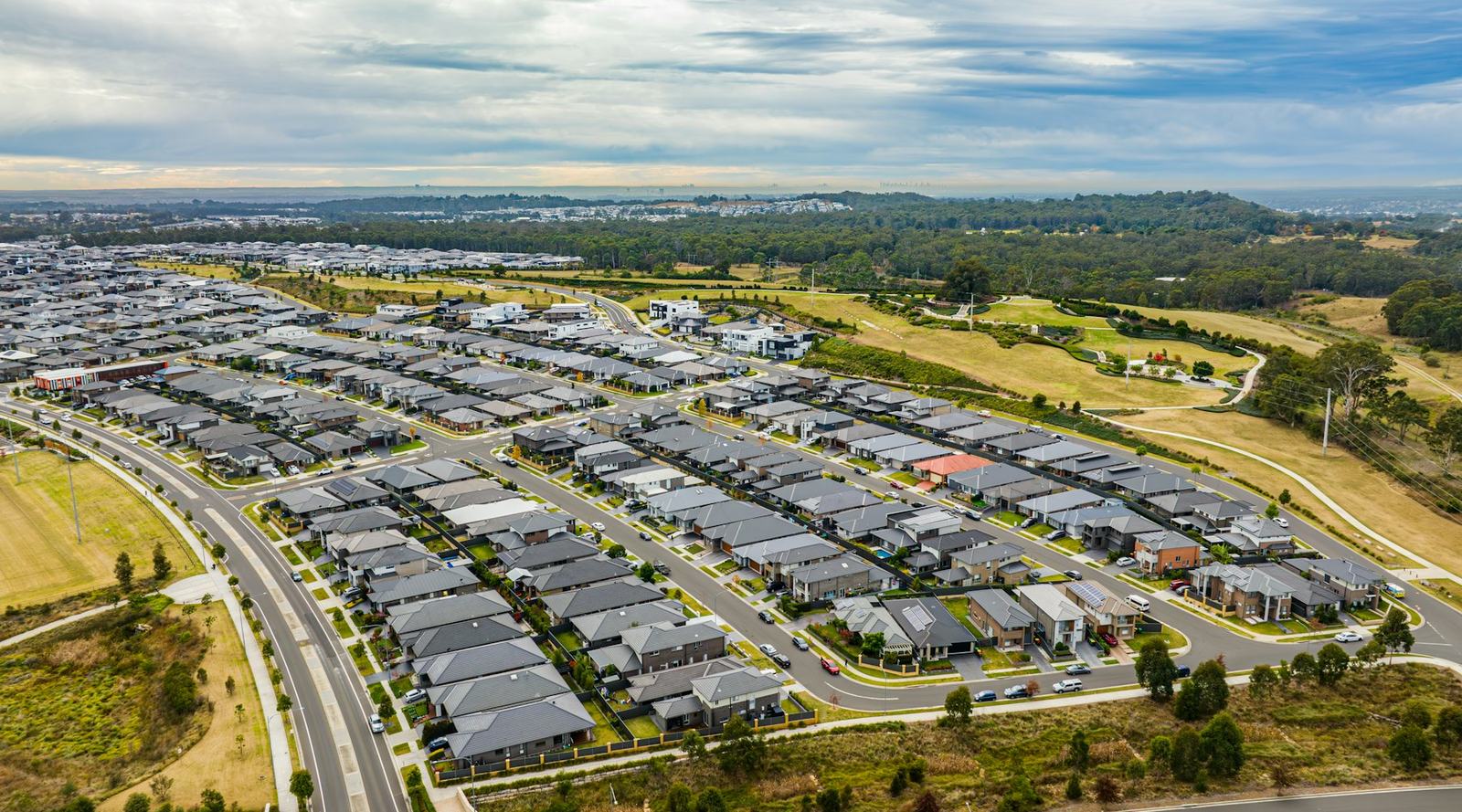 An aerial view of a growing suburb with rows of new homes